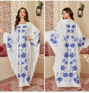Detail view of white satin kaftan with blue rose print and elegant batwing sleeves