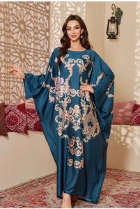 Detail of luxurious dark blue satin kaftan with golden baroque patterns and flowers