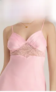 Close-up of pink satin nightgown featuring intricate floral lace patchwork and pleated cups