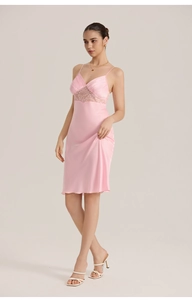 Close-up of pink satin nightdress with delicate lace V-neckline and thin shoulder straps