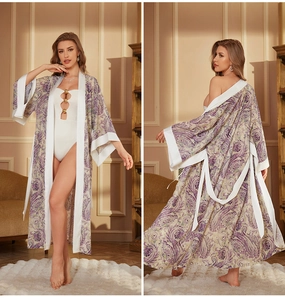 Détail du peignoir en satin cachemire avec poignets contrastés et maillot à anneaux dorés