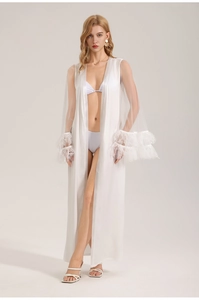 Detailed view of white satin robe featuring sheer mesh panels and elegant feather trim cuffs