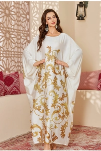 Detail of white satin kaftan featuring golden baroque patterns and elegant batwing sleeves