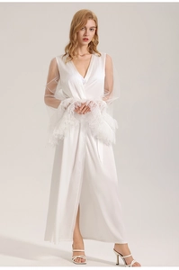Close-up of elegant white satin robe featuring sheer mesh sleeves with feather cuffs