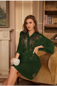 Detail of dark green satin robe featuring floral print and kimono sleeves in home setting