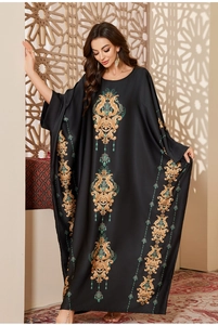 Detail of black satin abaya with gold baroque floral print and cyan gemstone patterns