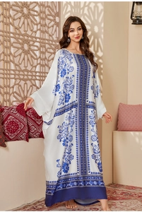 Detailed view of white satin kaftan featuring blue floral prints and elegant drape