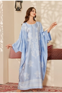 Detail of light blue satin kaftan featuring white floral print and batwing sleeves