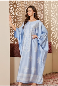 Detail of satin kaftan nightgown featuring ethnic patterns and light blue floral motifs