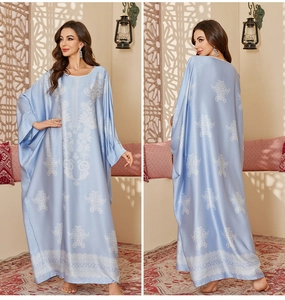 Detail of light blue satin kaftan robe featuring bohemian white mandala floral print