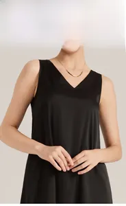 Gros plan du haut de pyjama en satin noir à col en V avec tissu soyeux et collier doré