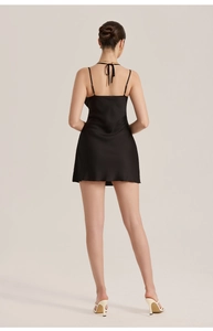 Detailed back view of a black satin mini dress featuring elegant lace-up cross straps
