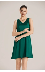 Détail d'une nuisette en satin vert foncé avec col en V et texture de soie lisse