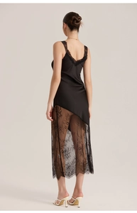 Détail d'une nuisette en satin noir avec dos nu et finitions en dentelle fine
