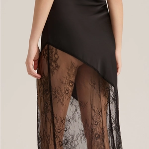 Nuisette élégante en satin noir avec dentelle florale et ourlet asymétrique