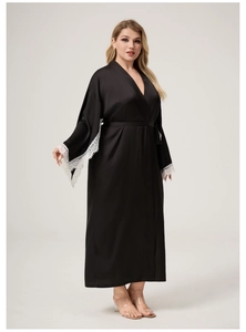 Detail of black satin robe featuring elegant white lace cuffs and smooth silk texture