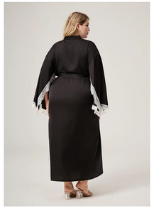 Detail of long black satin bathrobe with elegant white lace trim on the sleeves