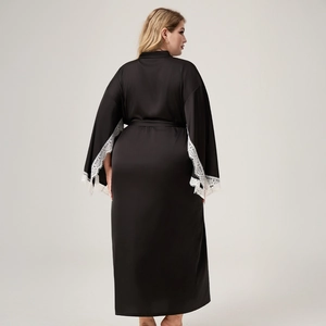 Macro detail of the contrast between black satin fabric and white floral lace on sleeves
