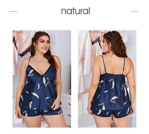 Detail of plus size navy satin pajamas featuring feather print and black lace trim