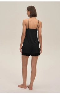 Detail of black satin pajamas set featuring delicate lace trim on the shorts back view
