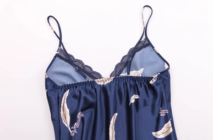 Detail of navy blue silk pajama with lace V-neckline and white feather print patterns