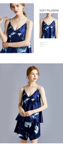 Detail view of navy blue silk pajamas with crane pattern and black lace V-neckline trim