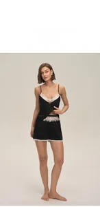 Détail d'un ensemble de pyjama en satin noir avec décolleté en V et bordure en dentelle