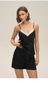 Détail d'un pyjama élégant en satin noir avec de délicates bordures en dentelle blanche