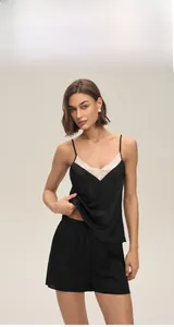 Détail de pyjama élégant en satin noir pour femme avec dentelle blanche et col en V