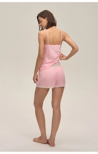 Détail du pyjama en satin rose avec bordure en dentelle blanche délicate sur le short