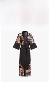 Close-up of elegant floral print on a long black satin robe with wide sleeves and belt