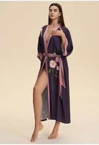 Detail of dark purple satin long robe with pink floral prints and silk finish texture