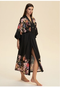 Detailed close-up of a black satin kimono robe featuring elegant floral patterns on the hem