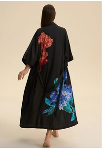 Macro shot of black satin robe featuring elegant floral print and silky smooth texture