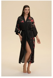 Detailed macro view of black satin bathrobe featuring elegant red plum blossom patterns