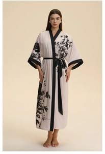 Detail of white satin long robe with black floral print and contrast piping trim