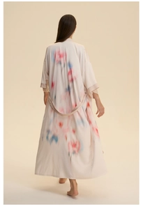 Détail d'un peignoir long en satin à imprimé fleuri avec manches larges et ceinture assortie
