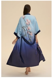 Détail de l'imprimé floral magnolia et feuilles de bambou sur le peignoir en satin