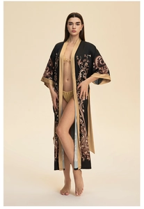Détail d'un peignoir élégant en satin noir et or avec motifs cachemire et fleurs