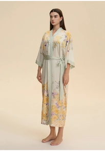 Détail d'un peignoir en satin à fleurs avec liseré vert menthe et ceinture élégante