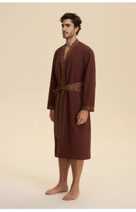 Detail of deep red men's loungewear robe with ethnic print trim on collar and cuffs