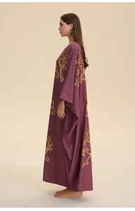 Detail of luxury baroque gold floral patterns on a loose purple kaftan dress