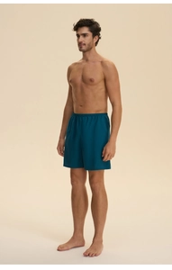 Detail of men's dark teal loungewear shorts with an elastic waistband and soft cotton fabric