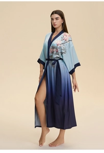 Détail de l'imprimé floral sur le peignoir en satin bleu dégradé avec motif magnolia