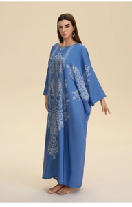 Detail view of the intricate white traditional prints on a navy blue kaftan maxi dress