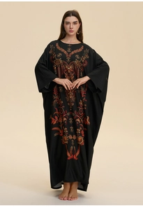 Detail view of intricate orange and gold floral embroidery on a black kaftan robe