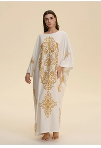 Detailed view of white kaftan with golden baroque print and elegant wide sleeves