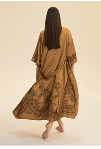 Détail du dos du peignoir en satin caramel avec fleurs en dentelle noire et drapé élégant