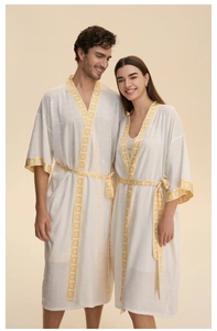 Détail d'un peignoir en satin blanc avec des motifs géométriques jaunes sur la manche et le col