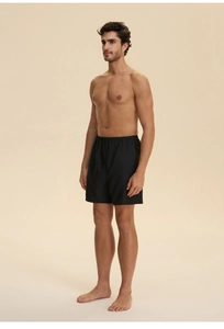 Detail of men's black lounge shorts with elastic waistband in soft cloud cotton fabric